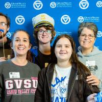 An alumni posing for a photo with her family.
